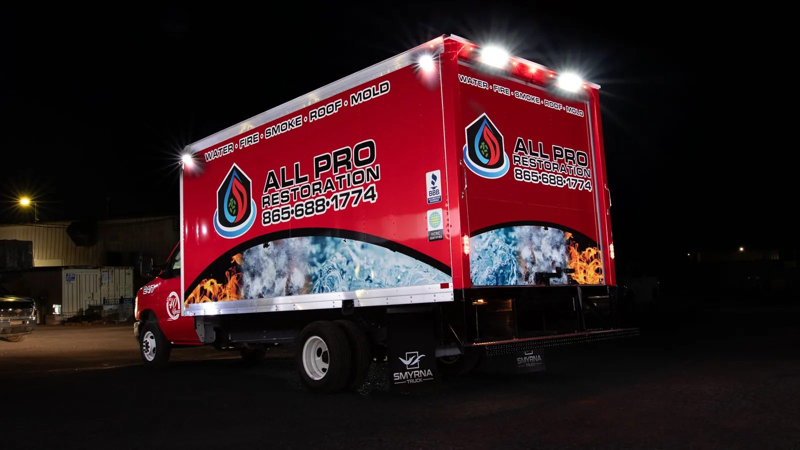 The same box truck at night with white LED work lights lit across the roof and rear corners